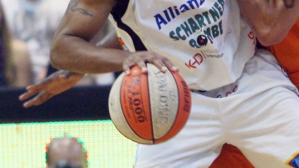 Ein Basketballspieler dribbelt einen Spalding-Ball.