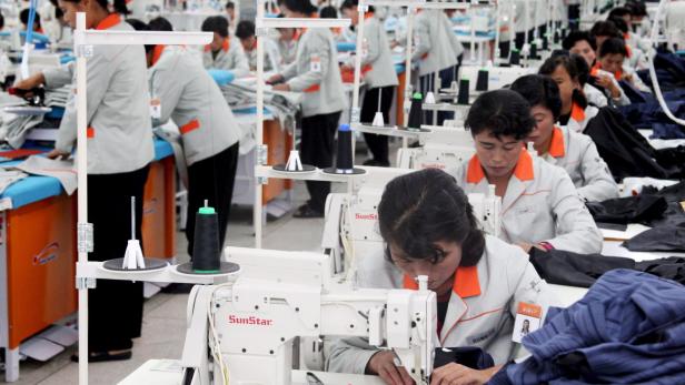 Frauen arbeiten in einer Textilfabrik an Nähmaschinen.