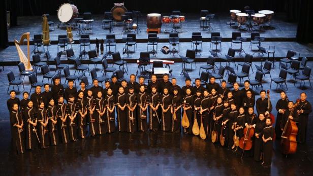 80 Musikerinnen und Musiker stehen im Brucknerhaus auf der Bühne.