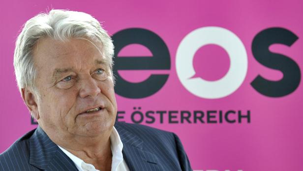 Ein Mann mit grauem Haar vor einem pinkfarbenen EOS-Hintergrund.