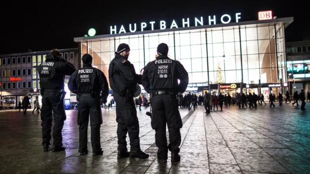 Polizisten stehen vor dem Hauptbahnhof bei Nacht.