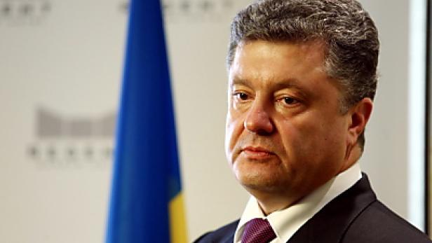Porträt von Petro Poroschenko vor der ukrainischen Flagge.