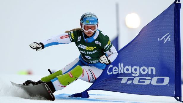 Eine Snowboarderin fährt einen Slalomkurs hinunter.