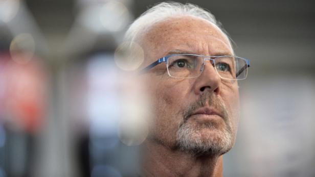 Ein Mann mit Brille und grauem Bart blickt nach oben.