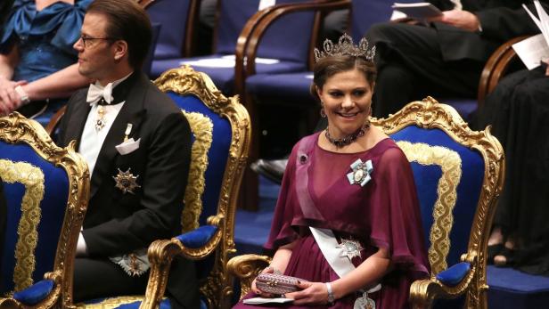 Kronprinzessin Victoria und Prinz Daniel sitzen bei einer Veranstaltung in verzierten Stühlen.