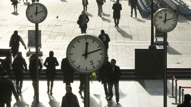 Workers walk past clocks showing a time of 12 minutes past 12 noon, on this century&#039;s last sequential date, in a plaza in the Canary Wharf business district of London December 12, 2012. REUTERS/Toby Melville (BRITAIN - Tags: SCIENCE TECHNOLOGY SOCIETY BUSINESS)