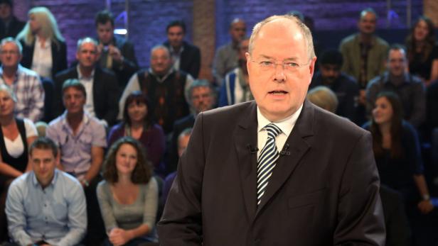 Ein Mann im Anzug spricht vor einem Publikum.