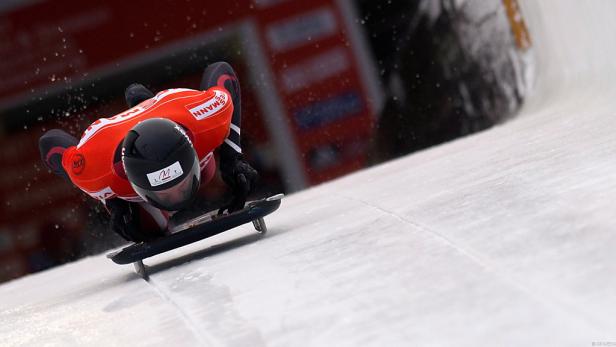 Ein Skeleton-Athlet rast auf einer Eisbahn liegend bergab.