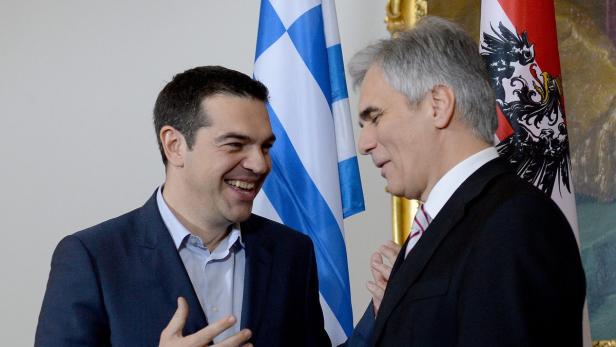 Alexis Tsipras und Werner Faymann bei einem Treffen vor griechischen und österreichischen Flaggen.