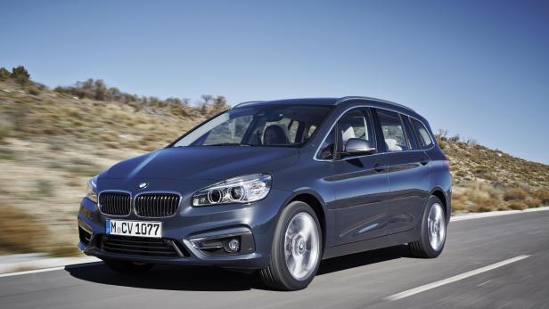 Ein grauer BMW 2er Active Tourer fährt auf einer Landstraße.