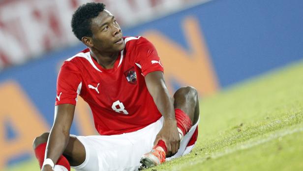 David Alaba im Trikot der österreichischen Nationalmannschaft sitzt auf dem Rasen.
