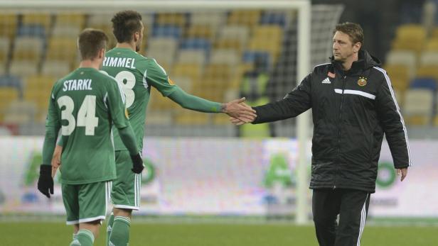 Ein Trainer gibt einem Fußballspieler die Hand.