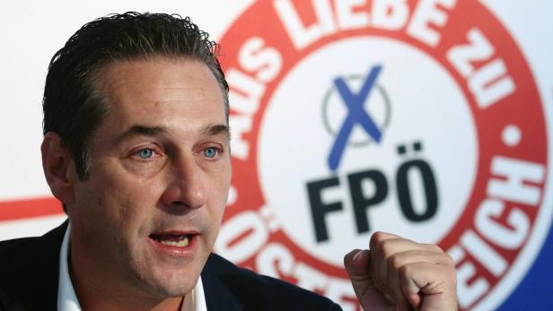 Ein Mann spricht vor einem Hintergrund mit dem Logo der FPÖ.