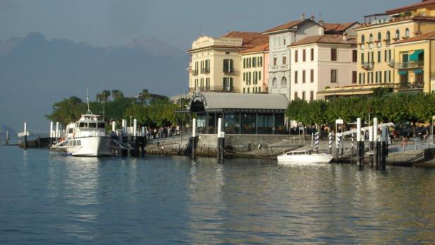 Blick auf den Comer See mit Booten und der Stadt Bellagio im Hintergrund.