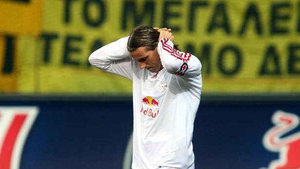 Ein Fußballspieler mit weißem Trikot hält sich frustriert den Kopf.