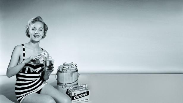 Eine Frau im Badeanzug gießt Bier der Marke Ortlieb's in ein Glas.