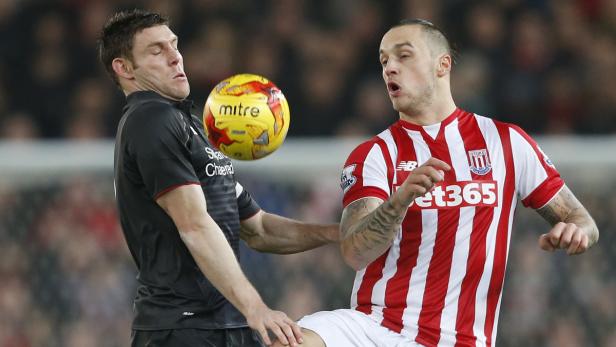 Zwei Fußballspieler kämpfen um den Ball während eines Spiels.