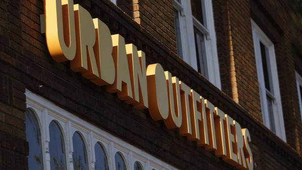 Das goldfarbene „Urban Outfitters“-Schild an einem Backsteingebäude.