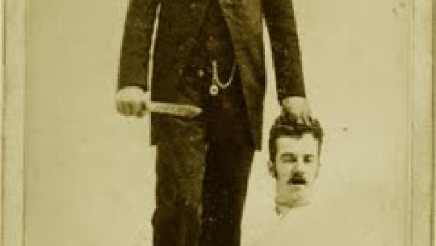 Ein Mann ohne Kopf hält seinen Kopf in der Hand und ein Messer in der anderen.