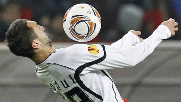 Ein Fußballspieler köpft einen Ball während eines Spiels.