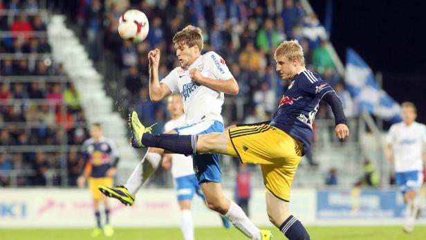 Zwei Fußballspieler kämpfen um den Ball während eines Spiels.
