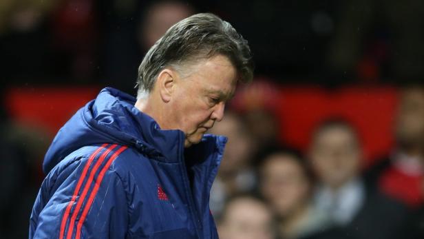 Louis van Gaal in einer blauen Jacke mit gesenktem Kopf.