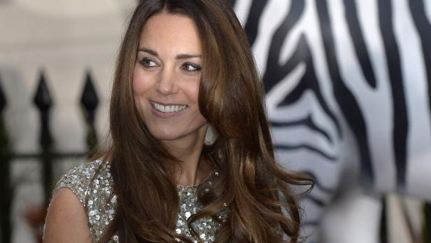 Catherine, Prinzessin von Wales, lächelt vor einem Zebra-Muster.