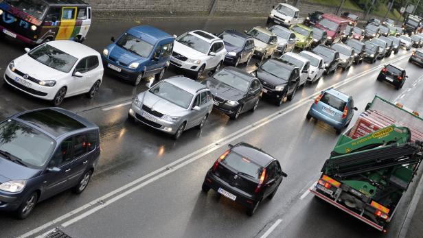 Auf einer nassen Straße staut sich der Verkehr.