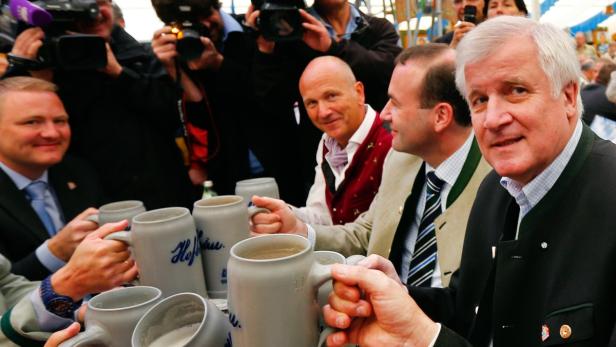Bavarian State Premier and leader of the Christian Social Union (CSU) Horst Seehofer (R) toasts with beer during an election campaign rally at the traditional Gillamoos festival in Abensberg September 2, 2013. Bavarian election will be held on September 15 and German General election on September 22. REUTERS/Michael Dalder (GERMANY - Tags: POLITICS ELECTIONS)