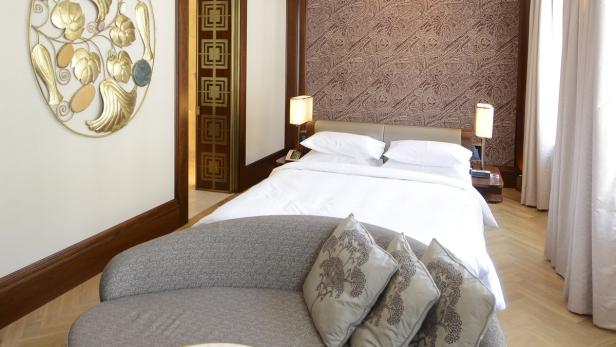 Ein Hotelzimmer mit einem Bett, einem Sofa und dekorativen Elementen.