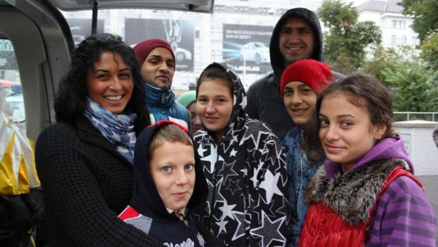 Eine Gruppe von Menschen steht zusammen im Laderaum eines Transporters.