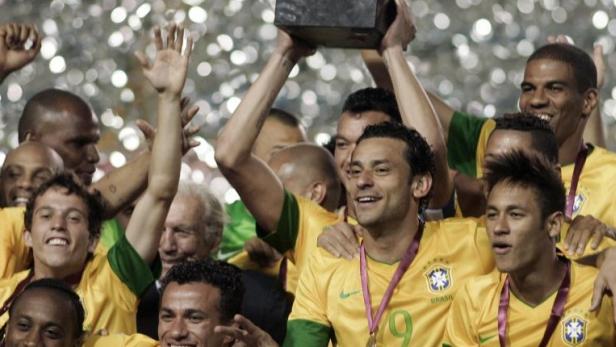 Brasilianische Fußballspieler feiern mit dem Pokal ihren Sieg.