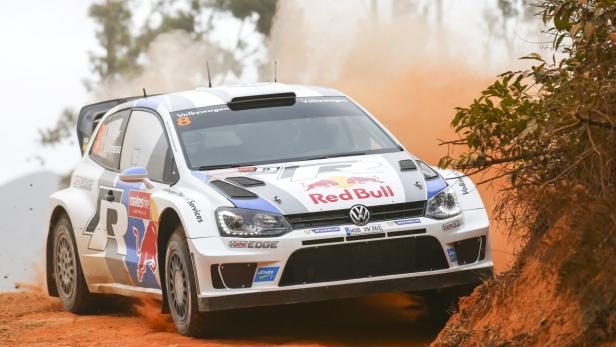 Ein weißer Volkswagen Polo WRC fährt auf einer staubigen Piste.