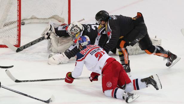 Ein Eishockeyspieler versucht, den Puck am Torwart vorbeizubringen.