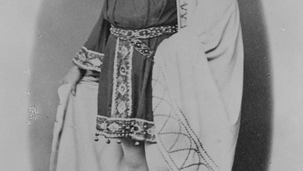 Ein Mann mit Bart und Krone, bekleidet mit einem verzierten Gewand.