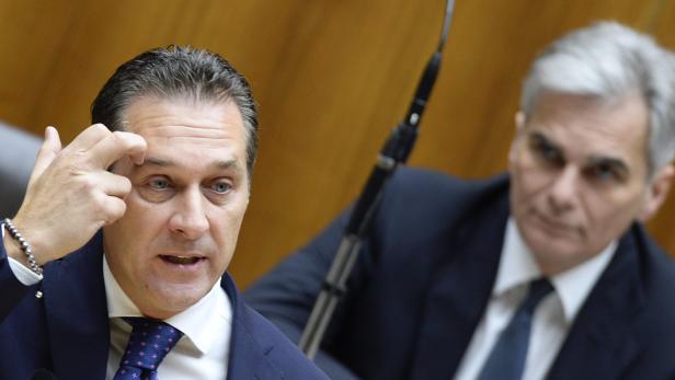 Zwei Männer in Anzügen während einer Rede.