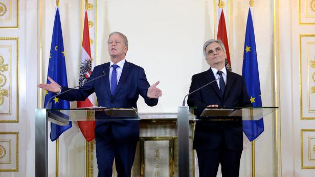 Zwei Männer in Anzügen stehen an einem Rednerpult vor österreichischen und EU-Flaggen.