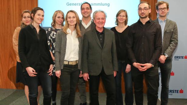 Eine Gruppe von zehn Personen posiert vor einer Leinwand mit dem Logo der Erste Group.