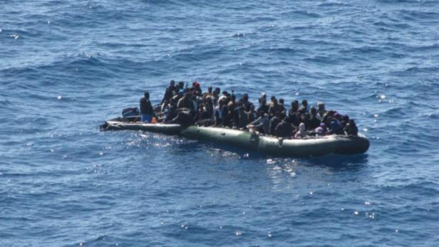 Ein überfülltes Schlauchboot treibt auf dem offenen Meer.