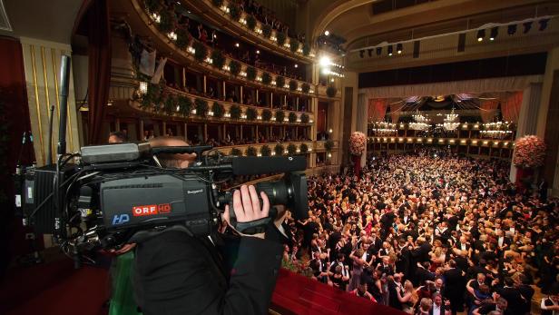 Ein Kameramann filmt den Wiener Opernball mit vielen tanzenden Paaren.
