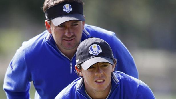 Zwei Golfspieler der Europa-Mannschaft tragen blaue Oberteile und Kappen.