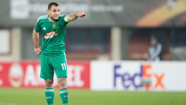 Ein Fußballspieler in Grün zeigt mit dem Finger nach rechts.