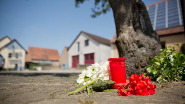 Blumen und eine Kerze liegen am Samstag in Tiefenthal-Leutershausen bei Ansbach (Bayern).