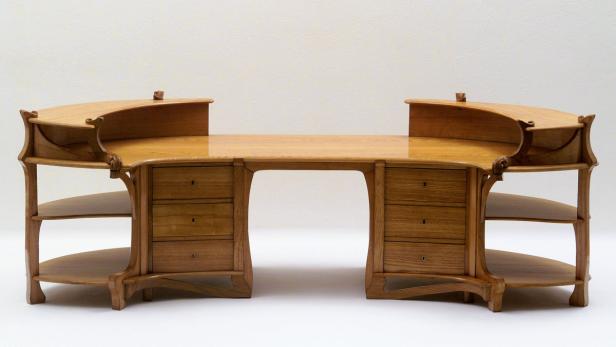 Ein hölzerner Jugendstil-Schreibtisch mit Schubladen und Ablageflächen.