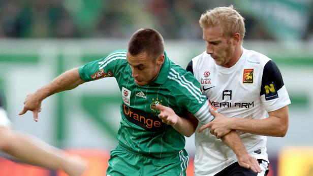 Zwei Fußballspieler kämpfen um den Ball während eines Spiels.
