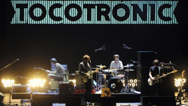 Die Band Tocotronic spielt live auf einer Bühne vor ihrem Bandnamen.