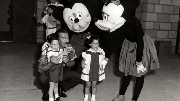 Walt Disney posiert mit Kindern und Mickey- und Minnie-Maus-Darstellern.
