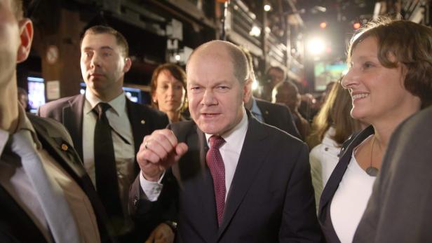 Olaf Scholz gestikuliert inmitten einer Menschenmenge.