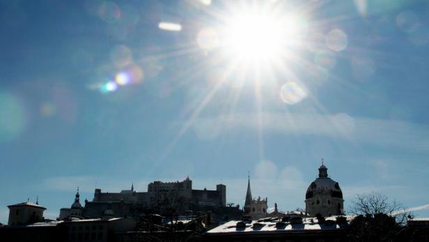 Die Festung Hohensalzburg und die Stadt Salzburg unter strahlendem Sonnenschein.