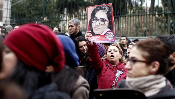 Eine Frau hält ein Schild mit dem Bild von Özgecan Aslan bei einer Demonstration hoch.